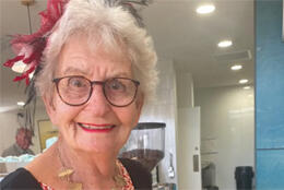 A grey-haired female priest looking directly into the camera