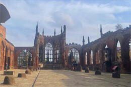 Gothic stone cathedral ruins stand exposed to the elements against a sky with gathering clouds