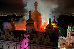 An onion domed Orthodox church glows orange as its roof burns