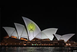 A single candle is projected  onto the fans of the Sydney Opera House
