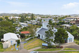 Aerial view of a modern church & historic hall in an Auckland suburb