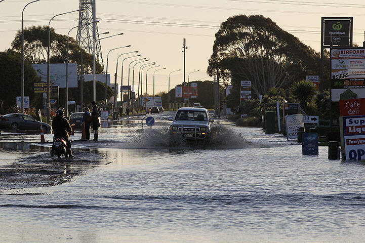 A vehicle drives through floodwater on Ferry Road, Christchurch. Photo: Martin Hunter/Getty Images 