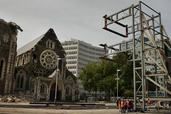 Emergency workers stand near the frame that will be used to hold the facade of ChristChurch Cathedral in place. Photo: The Press