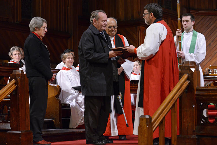 Archbishop John Paterson receives his citation from Archbishop Philip Richardson. John's wife Marion looks on.
