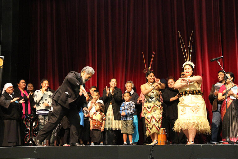Fr Iloa Tuineau can't resist the beat, as two Tongan sisters celebrate the slap dance.