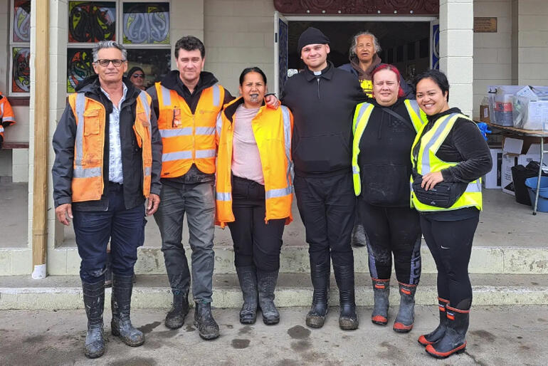 Rev Zhane Whelan stands with Omahu Marae clean up team members on 24 February 2023.