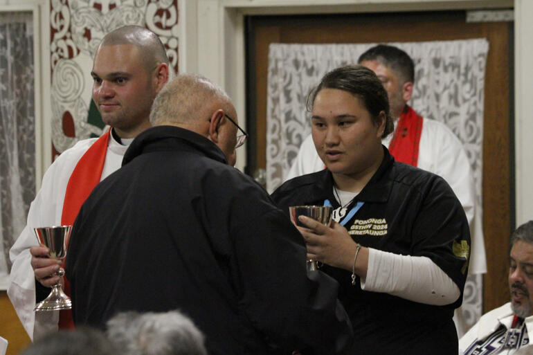 L-R: Rev Zhane Tahau Whelan and Haley Ruru serve communion during the Opening Eucharist of General Synod '24.