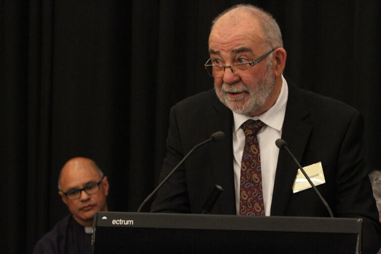 Matua Kim Workman talks while Rev Dr Paul Reynolds (Upoko o te Ika) waits to support the motion.