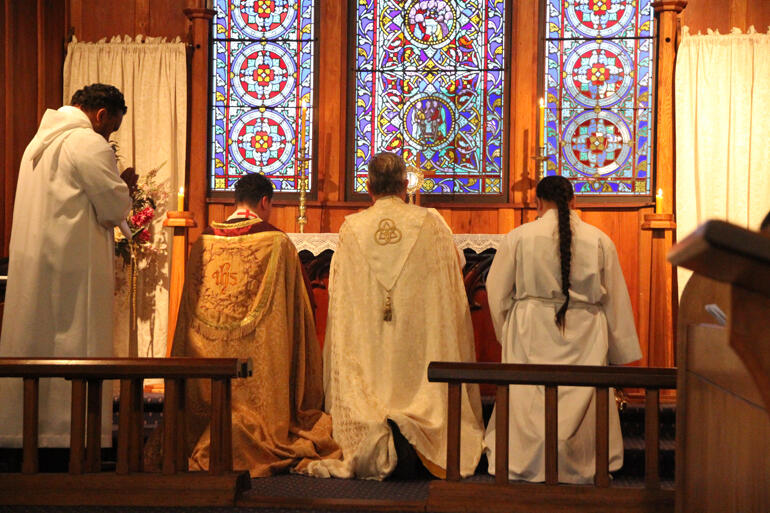 Pa Cruz, Archbishop David and Ataahua Jean kneel before the blessed sacrament during Benediction at St John's Te Awamutu.
