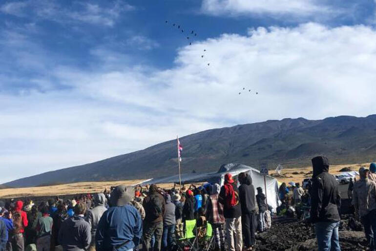 Visitors look toward the summit of Maunakea, the sacred mountain of the kanaka maoli people. Photo: Ryan Finnerty/HPR 