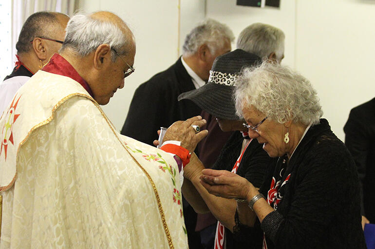 Archbishop Brown Turei serves The Host to Mrs Makere Beattie, of Manawa o te Wheke. Archbishop Brown Turei serves The Host to Mrs Makere Beattie, of Manawa o te Wheke.