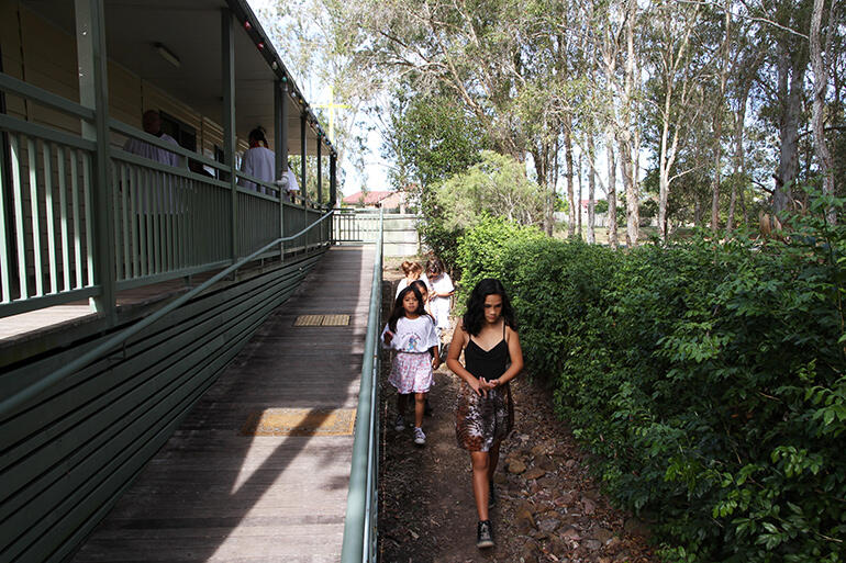 Young girls play alongside the wheelchair ramp up to the whare karakia. Young girls play alongside the wheelchair ramp up to the whare karakia.