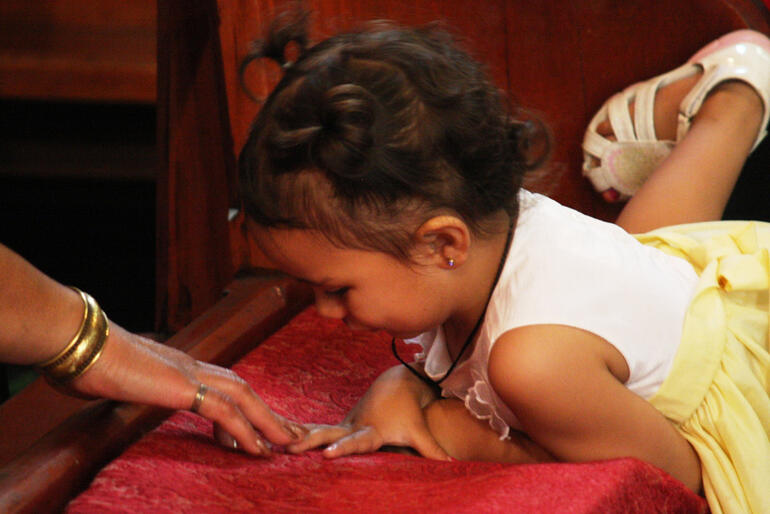 One of the younger crew at the powhiri makes her connection with an older friend.