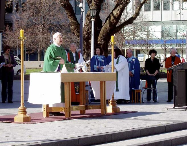 Dean Peter Beck leads the Great Thanksgiving during the Sunday morning open-air Eucharist in Cathedral Square.
