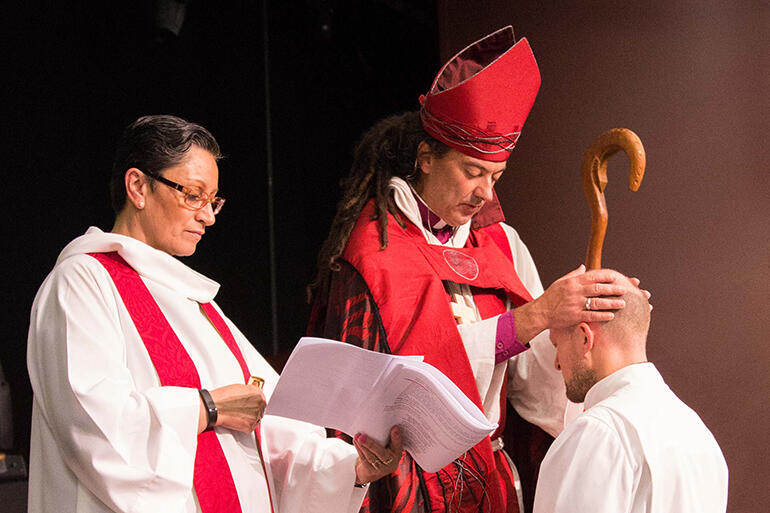 Bishop Justin lays hands on Andy Hickman, from Tawa Linden. Rev Cheryl Repia was the Bishop's Chaplain.