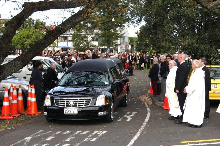 The hearse emerges from the honour guard, bound for the crematorium.