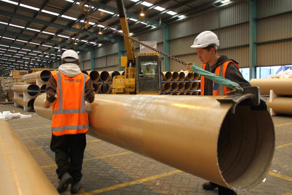 James Currie (left) and Ollie Foster-Taylor prepare another painted tube to be slung away by crane into storage racks.