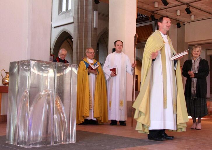 Dean Ross at the recent blessing of the cathedral's new cast glass baptismal font. The artist, Ann Robinson, is at right.