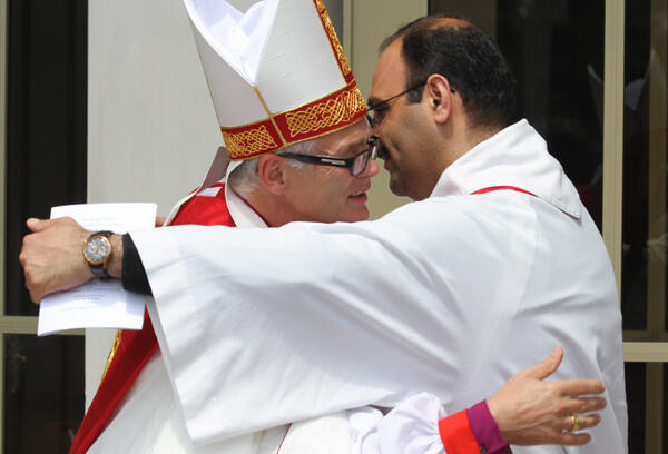 Rev George Al-Kopti embraces the new bishop. Fr George is a Palestinian priest studying for his doctorate at St John's College.