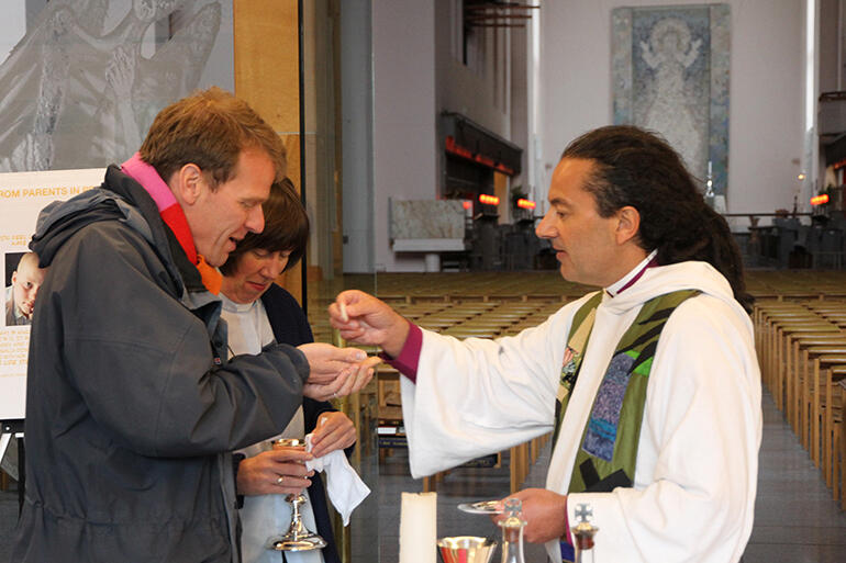 Bishop Justin distributes the host to the Rev Simon Winn - as the the Rve Jenny Wilkens looks on.