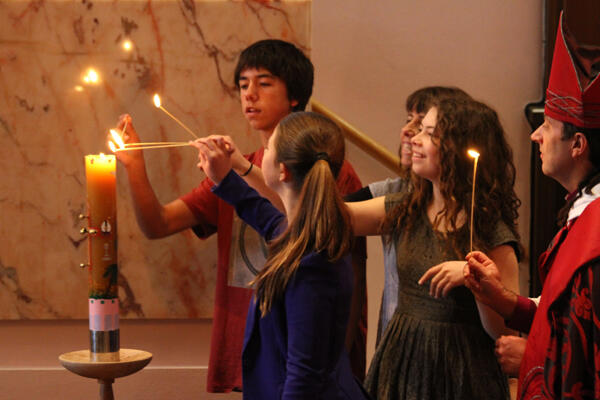 Bishop Justin,Jenny and their family light the Paschal Candle.
