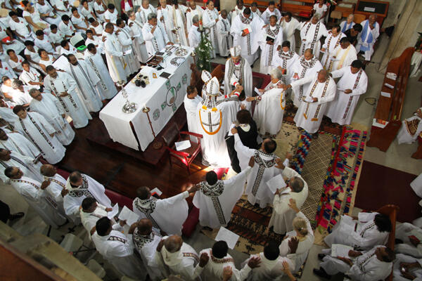 The priests of the diocese form an unbroken chain around a newly consecrated priest.