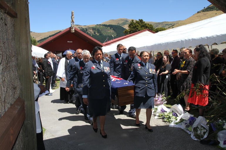 Air Force personnel bear +Richard out of the funeral service at Wairewa Marae. 