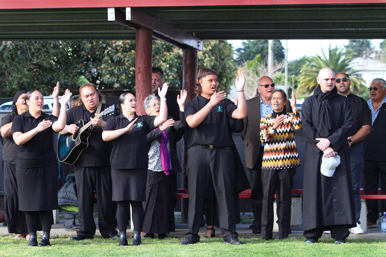 Rev Zhane Tahau Whelan (right) joins a himene as he leads prayers to conclude the pōhiri at Ōmahu. Rev Zhane Tahau Whelan (right) joins a himene as he leads prayers to conclude the pōhiri at Ōmahu.
