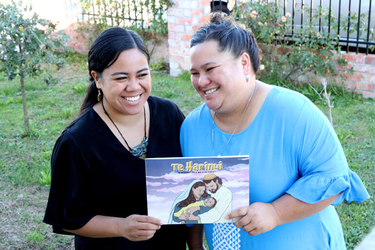 Caughey Teisi and Sophie Anania hold onto the new picture book nativity in te reo Māori by Sophie, Hinekura Simmonds & Rebecca Kereopa.