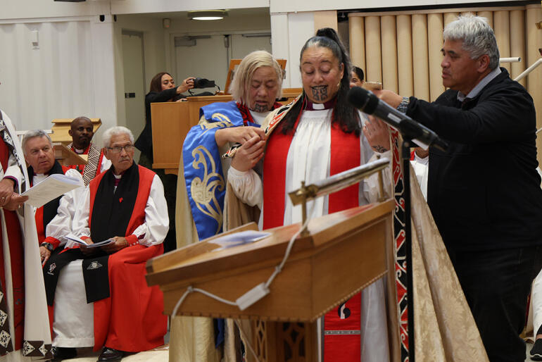Archdeacon Mere Wallace and Snow Tane vest Bishop Susan with the cope of her great grand uncle Bishop Wiremu Nētana Pānapa.