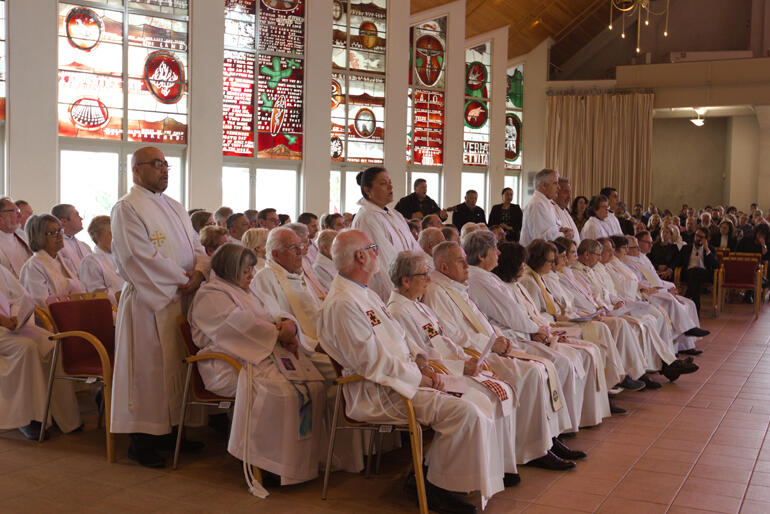 Clergy from Te Pihoptanga o Te Tai Tokerau rise to support Bishop Kito Pikaahu in song.