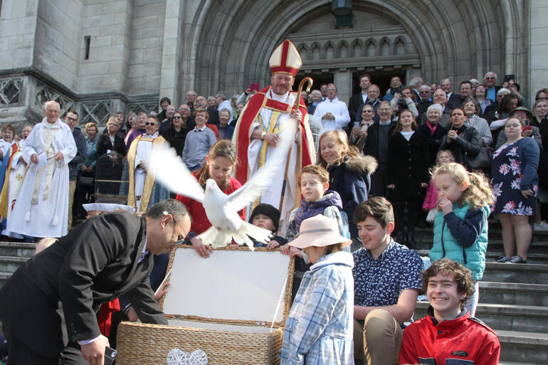 Another of the 25 doves fly from the cathedral steps.