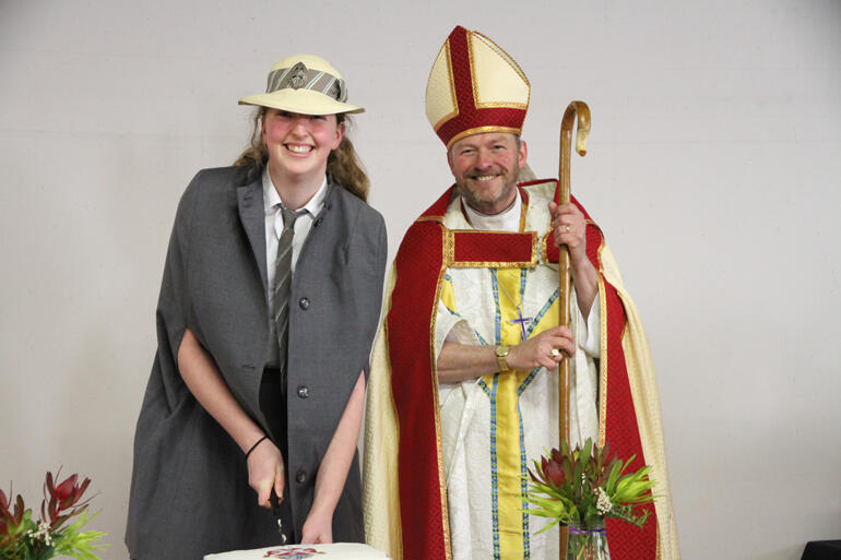 St Hilda's Collegiate School sacristan Lily Chamberlain cuts the 150th anniversary cake with Bishop Steven Benford.