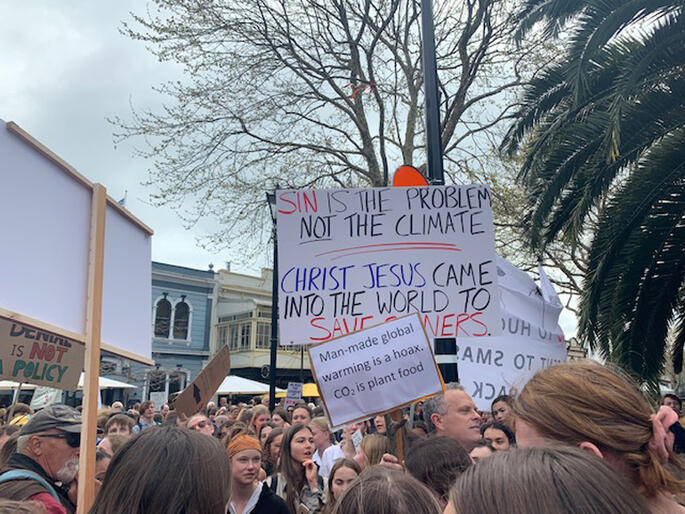 Christian signs at the Nelson climate strike lead to a public street theology exchange.