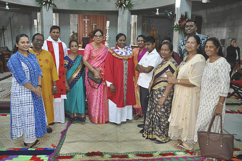 Newly ordained priest Rev Reena Prasad lines up in her red chasuble with members of St Matthew's Anglican Church.