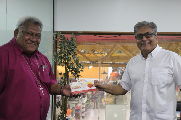 Archbishop Fereimi Cama collects food vouchers from RB Patel Company for the Diocese to distribute in parishes around Fiji.