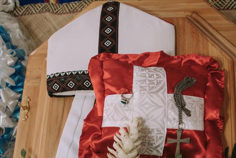 Archbishop Fereimi's symbols of episcopal office: his mitre, pectoral cross and episcopal ring, lie on his casket.