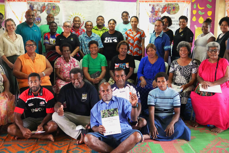 Gardening skills workshop participants gather for a group photo with certificates outlining their newly acquired skills.