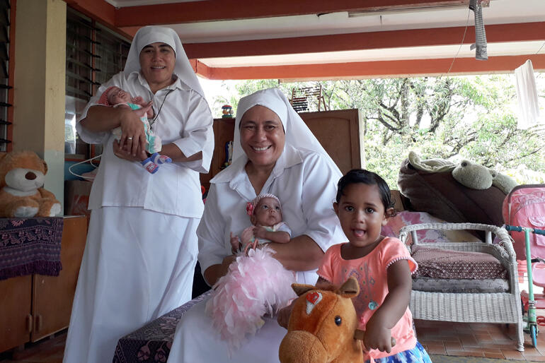 Sr Longo and Sr Kalolaine with two of the babies and a toddler who live at St Christopher's Home in Suva.