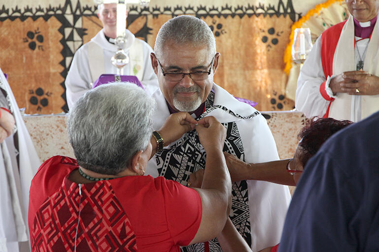 Archdeacon Amy Chambers adjusts the new bishop's cope.