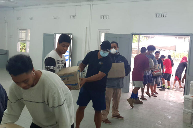 A team installs emergency boxes indoors during the Tongan Anglican Church's first distribution of essential supplies following this year's eruption.