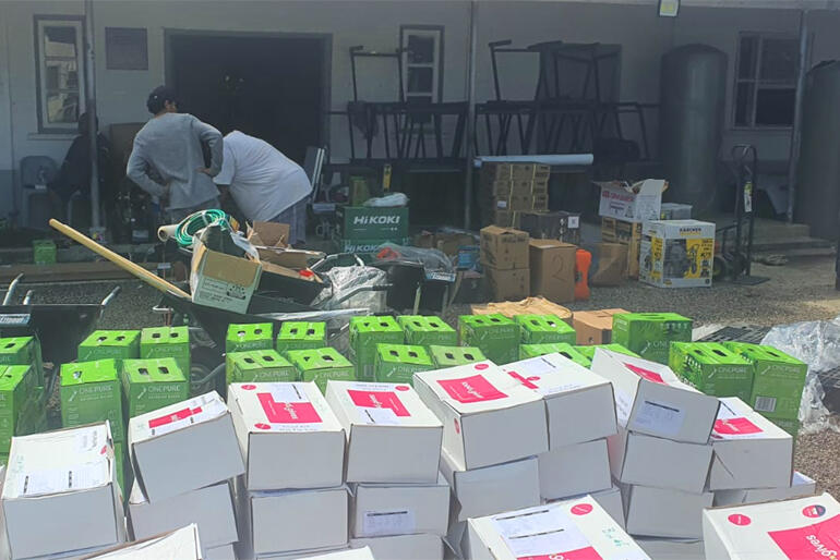 Boxes of water and emergency food, tools and gardening equipment wait for distribution after Tonga's eruption and tsunami this February