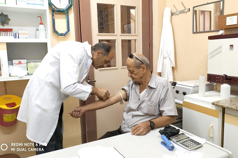 A doctor treats a patient at the Penman Medical Centre in Zababdeh.