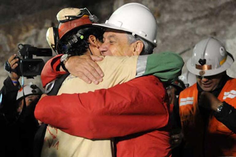 First out of the mine: Chilean miner Florencio Avalos is embraced by President Sebastian Pinera.