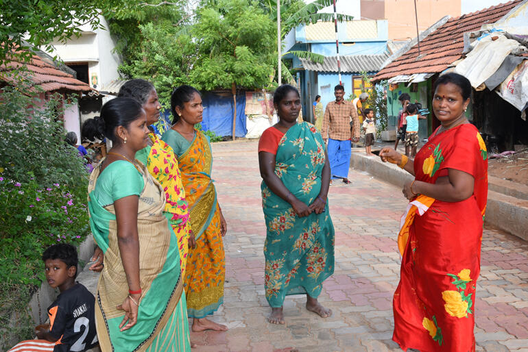 Newly empowered by her sangam, Muneeswari (in red) talks with women in a village street in Tamil Nadu, India. Photo:WDRC