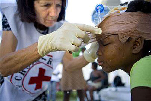 Canadian Red Cross nurse Suzanne Puzo removes bandages from Danise Diverge, 10, in Croix Desprez, Port-au-Prince.